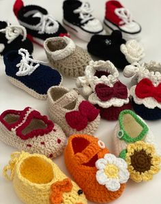 there are many crocheted baby shoes on the table