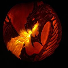 a carved pumpkin with a dragon on it's face and flames coming out of its mouth