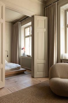 a chair sitting in front of a window next to a bed and a radiator