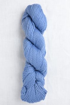 a skein of blue yarn sitting on top of a white surface with the end of it