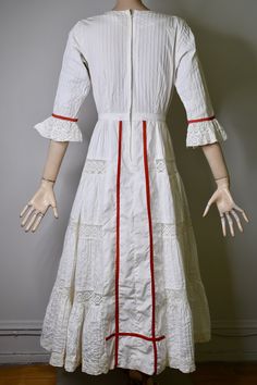 "This dress is so special. It is a vintage 60s/70s Mexican pin tucked white dress. The dress has a square neckline, that is trimmed with red ribbon and small lace ruffles, is fitted to the waist with a floral embroidered bodice that is also finished on the side with red ribbon, it has 3/4 sleeves with a flared lace cuff and red ribbon trim, The skirt is a long maxi skirt that is quite full, it has a front and back center panel with red ribbon running down the length, coming off the front panel i Fitted Broderie Anglaise Maxi Dress, White Victorian Dress For Garden Party, White Victorian Vintage Summer Dress, White Fitted Victorian Dress For Garden Party, Vintage Broderie Anglaise Wedding Dress, White Victorian Wedding Dress For Summer, White Broderie Anglaise Regency Dress, White Regency Broderie Anglaise Dresses, White Regency Style Broderie Anglaise Dresses