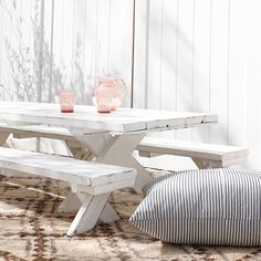 a white table and bench sitting on top of a rug