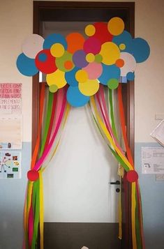 a bunch of balloons that are on top of a door frame with ribbons and streamers