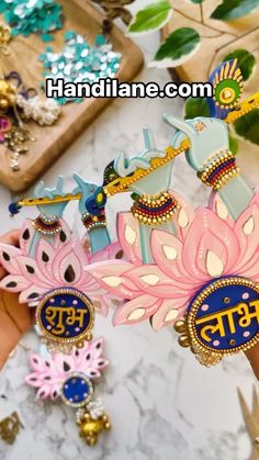 a person holding some colorful brooches in their hand on a marble counter top