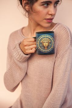 a woman holding a coffee cup with a lion head on it's mug sleeve