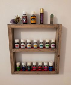 a wooden shelf filled with lots of different types of essential oils on top of each other