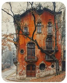 an old building with many windows and balconies on the outside, next to a leafy tree