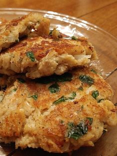 three crab cakes are stacked on top of each other in a glass plate, ready to be eaten