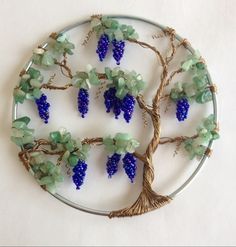 a wire tree with grapes on it is shown in the shape of a brooch