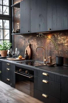 a kitchen with black cabinets and wooden floors