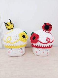 two crocheted cupcakes with ladybugs on them sitting next to each other