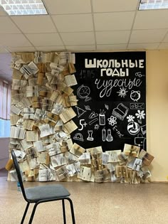 a chair sitting in front of a blackboard with writing on it and lots of books