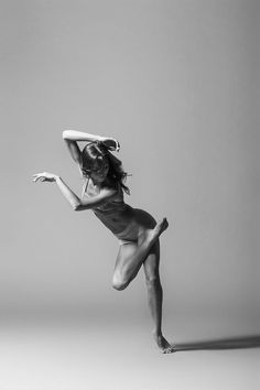 a woman in a bathing suit is posing with her arms outstretched and legs spread out