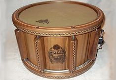 a wooden drum case sitting on top of a white wall