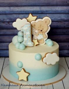 a blue and white cake with a teddy bear on it's number one frosting