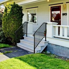 a white house with stairs leading up to the front door