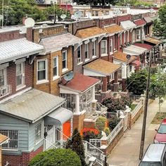 a row of houses with cars parked on the street