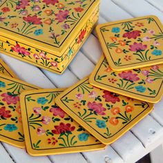 four yellow plates with colorful flowers on them