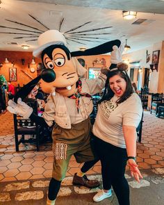 two women pose with goofy the dog mascot