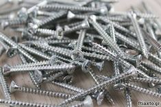 a pile of screws sitting on top of a wooden table