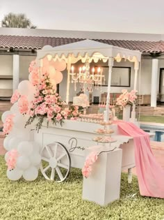 an ice cream cart decorated with pink flowers and balloons