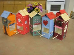 several small cardboard houses are lined up on the floor