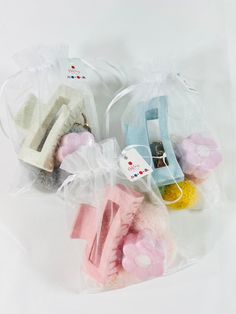 several small stuffed animals in plastic bags on a white surface