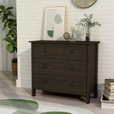 a brown dresser sitting in a living room next to a mirror and potted plant