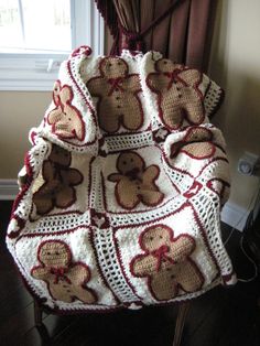 a crocheted teddy bear afghan sitting on top of a chair next to a window