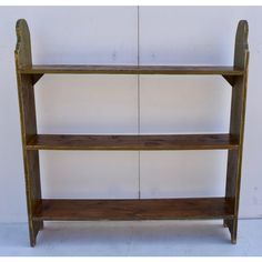 an old wooden shelf with three shelves on each side and two hooks at the top