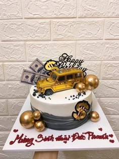 a white and gold birthday cake with money on top