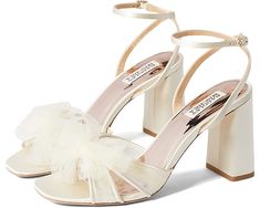 a pair of white high heeled shoes with a bow