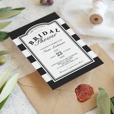 a black and white striped bridal shower is on the table next to an envelope