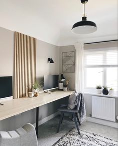 a room with a desk, chair and computer on top of the desk in front of a window