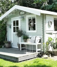 a small white house sitting on top of a lush green field