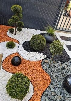 an outdoor garden with rocks, gravel and trees in the shape of circles on top of each other