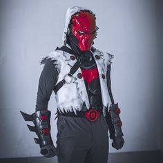 a man in a costume with red and white paint on his face, holding two knives