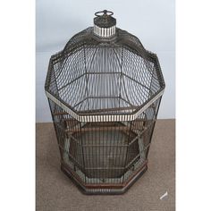 a metal bird cage sitting on the floor