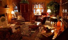 a living room filled with furniture and a fire place next to a window covered in curtains