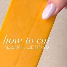 a person holding a piece of cheese with the words how to cut sharp cheddar