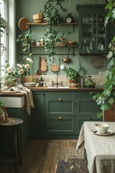 a kitchen filled with lots of green cupboards and plants on top of the cabinets