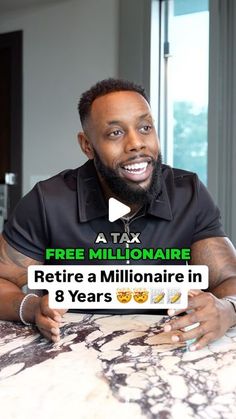 a man sitting at a table in front of a sign that says free millionaire