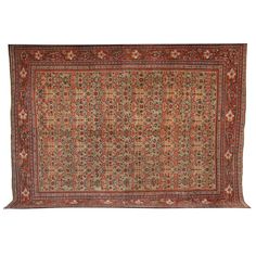 an antique persian rug with red, green and blue flowers on the center is laying on a white surface