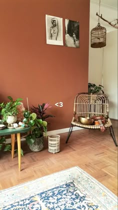 a living room filled with lots of furniture and plants on top of a hard wood floor