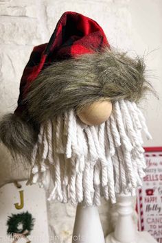 a doll is wearing a red and white hat with fringes on it's head