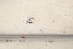 an aerial view of the beach with a red car