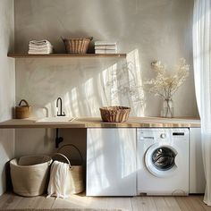 a washer and dryer sitting in a room next to a shelf filled with towels