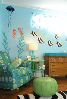 a baby's room decorated in blue and green with sea animals on the wall