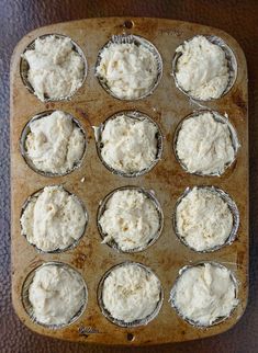 a muffin tin filled with lots of white frosting