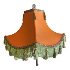 an orange lamp shade with tassels and beads